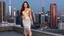 Placeholder: very beautiful lady with makeup long curvy hair pretty official midi lace velvet silver skirt with a lace loose bra, high heels, full body posing_to_camera in a modern city on roof of a skyscaper stage