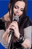 Placeholder: attractive female country music singer leaning forward while holding microphone in front of them, change clothing to plaid in natural tones, leather bracelets on wrists, long hair, mouth open, singing, rings on fingers