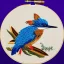 Placeholder: metallic kingfisher in embroidery hoop, intricate, highly detailed