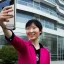 Placeholder: A short haired, Japanese female software engineer taking a selfie in front of Building 92 at Microsoft in Redmond, Washington