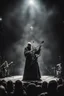 Placeholder: papež hraje na pódiu v blackmetalové kapale na baskytaru a řve do mikrofonu, ponurá atmosféra, veliká scéna koncertu, pentagram, obrácený kříž, veliký kontrast, hodně detailů, fotorealistické, RAW