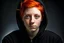 Placeholder: A woman with short, bright red hair, brown eyes, wearing a black hoodie.