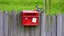 Placeholder: an old wooden fence with a little bird on it, a red old mailbox on the fence, a big note stuck on the mailbox