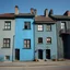 Placeholder: Fotografia di strada assurda e falsa orripilante blu weirdcore dai colori vivaci. Yves Tanguy. Non luogo falso, inusuale. Max Ernst. Le case sono false e dipinte di nero chiaro con cose stilizzate e dettagli. Ci sono finestrelle false quadrate, che danno un senso distopico e molto surreale, disposte in modo casuale. L'atmosfera generale sembra noiosa e onirica, con un contrasto tra elementi reali ed elementi dipinti falsi, René Magritte, oddest things