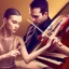 Placeholder: woman playing piano and man playing violin on stage