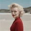 Placeholder: Marilyn monroe with pony tail, in a large red woollen sweater, on the beach, in the sun