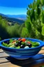 Placeholder: Greek salad with lettuce and black olives in a blue glazed bowl on a wooden table with the hills of grease in the background with all of the trees and rolling green hills