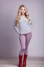 Placeholder: beautiful 18 year old girl with ash blonde hair and blue eyes with her curvy hair down, wearing a long-sleeved woollen top, and lilac long leggings, with long red boots full body shot