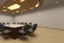 Placeholder: square meeting room and a table in the middle for 12 people and the walls are brown and the table