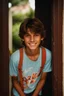 Placeholder: 15 year old young boy with lightly tanned skin and medium length brown hair wearing a teeshirt, standing by a door, smiling