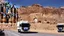Placeholder: A police Tesla Cybertruck is chasing a Tesla 'Model S Plaid' at top speed, at Petra, in Jordan. CINEMATIC. WIDE ANGLE LENS.