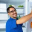 Placeholder: Refrigerator repairman with eye glasses is smiling and working on the big refrigerator