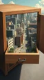 Placeholder: Make an open drawer of a cabinet contain inside it a surreal modern city with buildings and streets from top view Bosch painting style