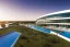 Placeholder: Sunset algarve in quinta do lago, one straight line building of 250 meters long modern luxury architecture with pool on rooftop, with green roofs and sun loungers next to pool, overlooking the campus sport facility and inserted in the Ria Formosa Natural park, on a slope with pinus pinea, a wrap around low speed veicular road