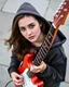 Placeholder: attractive woman wearing a hoodie and playing an electric guitar at high angle