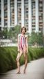 Placeholder: beautiful anorexic asian girl, total shot, shiny horizontally striped triathlon swimsuit, short blond wavy bob hair, blurred city background