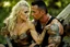 Placeholder: Jason David Frank Very muscular man with short hair and tribal tattoos piercings carrying very pretty thin blonde girl bridal style