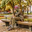 Placeholder: A figure of a man thinking about complex issues sitting on a park bench.