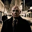 Placeholder: very grainy discolored photo, portrait, dark night street, grunge, 2000s Russia, punk, outcast, rough, confident, bald older male wearing a coat, extremely pale skin, large flesh bulbs grow out of his face and covering a lot of it, face is disproportionally deformed, hunchback, sewer dweller