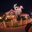 Placeholder: photograph taken by a gopro camera of a large suburban house and landscaping and fence with an insanely detailed Christmas light display lit up at night. Christmas lights on everything, Santa's sleigh and reindeer on roof all lit up with individual christmas lights, christmas light on everything to an unbelievable degree, 100,000 individual lights, ridiculous and impossible amount of lights, can be seen from space