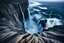 Placeholder: massive intimidating rock cliffs ascend all around and further up out of view. far below, the stormy ocean swirls intimidatingly. The ocean water falls off a waterfall down into a circular pit