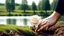 Placeholder: a young woman's hand planted a white rose stem in the ground, in the background a lake, some green trees, ultra detailed, sharp focus, perfect hands, perfect photo