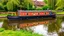 Placeholder: Historic traditional English canal barge, long boat on an English canal. The boat is beautifully painted in an ornate, colourful traditional style. Award-winning colour photograph.