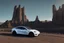 Placeholder: A Tesla 'Model S' is going at a high speed, near the 'Devils Tower' in Wyoming. (CINEMATIC, WIDE ANGLE LENS, PHOTO REAL)