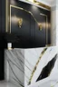 Placeholder: Black reception desk with white marble wall veined with gold