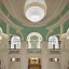 Placeholder: opulent and luxurious pale seafoam and white color mediterranean revival style hall; view from the huge central hall looking up at the building