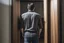 Placeholder: man in jeans and a shirt, back to the camera, standing in a row of doors, looking out through a doorway
