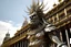 Placeholder: 3D Render of , High Detailed, ; a deity covered by long metallic fringes straps; moving rapdly-blurried; BACKGROUD: 1600 city; colonial architecture; barroco churches