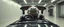 Placeholder: car driving happy 2d neon fluffy orc wheel test dummy hippo lord with human hands in the style of Escher and Giger and Fallout 4, pinhole cam, airbrush 3d rendering, on tv screen:A five-second cinematic single take in a clean industrial presentation hall.
