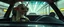 Placeholder: car driving happy 2d anime fluffy slimy slug alien sloth gremlin woman in the style of Escher and Giger and Fallout 4, pinhole cam, airbrush 3d rendering, on tv screen:A five-second cinematic single take in a clean industrial presentation hall.