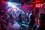 Placeholder: dans golv på en nedsliten sunkig techno club, många personer som dansar, yppiga kvinnor, mycket scen rök i lokalen, och gula röda strobes, en del personer ser in i kameran och skriker: "Benny!" och en Neon Skylt med texten "DJ ROY" på väggen, DJ Roy skriker rätt in i kameran, öppen mun, mycket flaskor och glas i baren