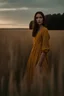 Placeholder: A mysterious brunette woman with sharp cheekbones is standing in a field in Thuringia at dawn. She is wearing a mustard linen dress and seen from afar. The sky is pale blue. The photo is taken with an iPhone.