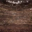 Placeholder: a single chair on stage under spotlight at a dark and empty symphony hall as seen from stage