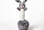 Placeholder: Scruffy fluffy grey puppet plush dust Bunny, holding with both hands onto a post while being blown vertically by the wind, extending vertically, comedic, on white background