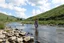 Placeholder: country side small river nice rocks at floor wild flowers blosom pretty sky and cloudes a beautiful young lady standing gracefully in water