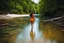 Placeholder: beautiful girl walking toward camera in trees next to wavy river with clear water and nice sands in floor.camera capture from her full body front