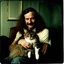 Placeholder: Awkward portrait Photo, 40 years old sitting on chair, weird smiling, long 1970 hair and mustasch, bland polaroid camera, holding a cat