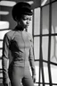 Placeholder: (Achieving unparalleled quality and hyper-realism), this photograph was expertly captured with a vintage Hasselblad 500 C/M 1957 camera, showcasing a youthful portrayal of Nyota Uhura. She is seen wearing a sleek and practical Star Trek Starfleet gym suit, exuding confidence while stationed in the space dock. The scene is set amidst a natural, moody backdrop with soft, diffused lighting that accentuates her explorer-like presence. The careful composition of the image casts captivating shadows, h