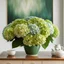 Placeholder: Huge bouquet of hydrangea in light green and dark green color ,in a white stylish ceramic flower vase on a Wood table with a modern painting behind on the wall