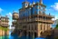 Placeholder: medieval buildings with balconies overhanging lake edge with blue sky and people, photorealism, fantastical, intricate detail, splash screen, concept art