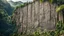 Placeholder: flat wall of rock in the jungle at the foot of the mountain