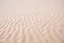 Placeholder: wavy rippled beach sand, foreshortened