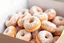 Placeholder: a box of fresh old-fashioned mini doughnuts completely covered in powdered sugar