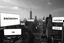 Placeholder: greyscale cityscape upshot: minimalism, many large white billboards populate the city with black block lettering with single word choose randomly between: "BIOMORPH" || "CB" || "SPATCHCOCK" || "TANGUY", || "SURREAL". || 'They Live' movie still, city panoramic, concept art, subliminal messaging