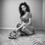 Placeholder: she is sitting down on the floor in black and white zebra, showing off her sandals