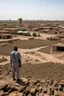 Placeholder: Sudan, destroyed city, airstrikes, one man in the distance